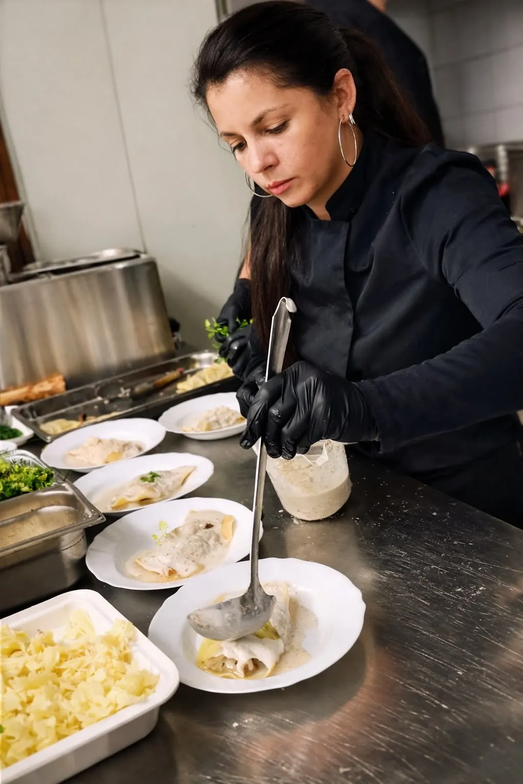 La cheffe dresse les assiettes en cuisine