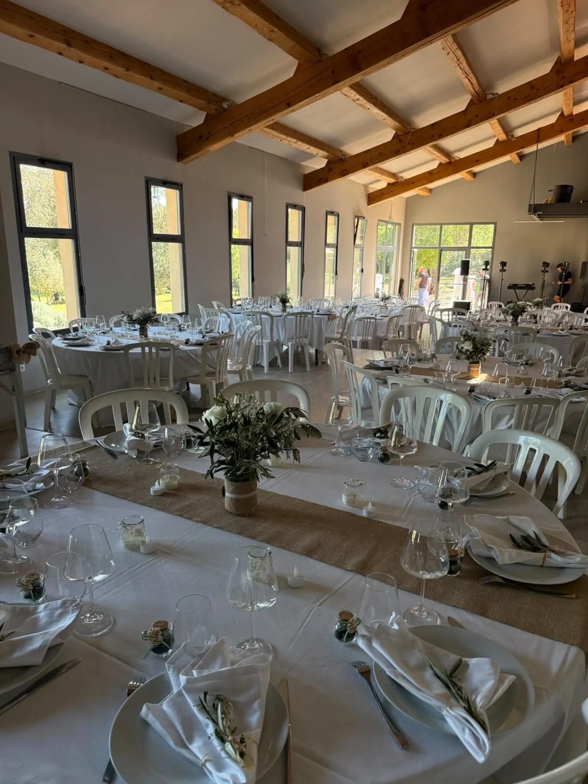 Salle de réception d’un domaine du Var, tables dressées sous poutres apparentes